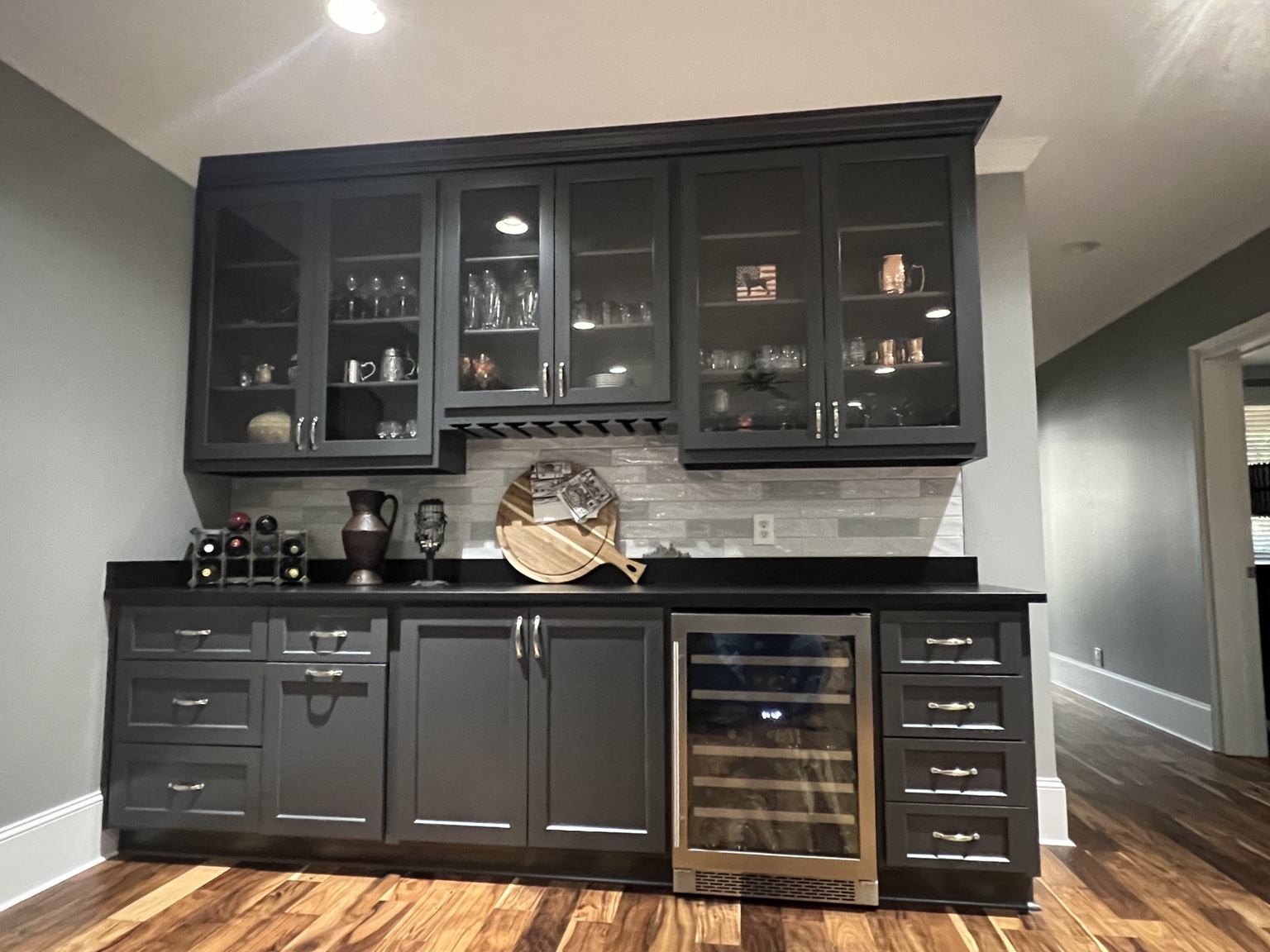 Black built-in bar cabinetry with glass display doors