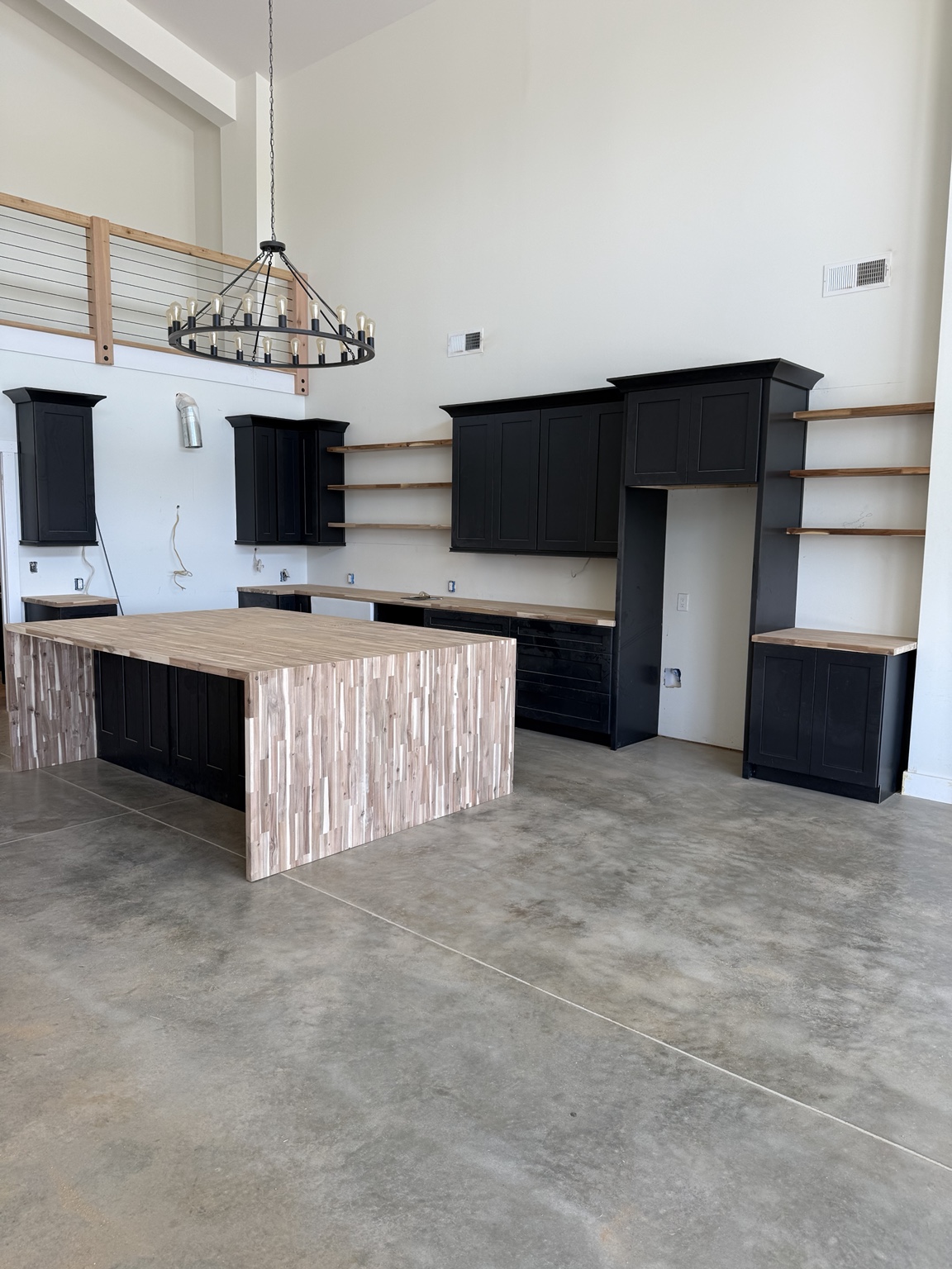 Black custom kitchen cabinetry and island during installation