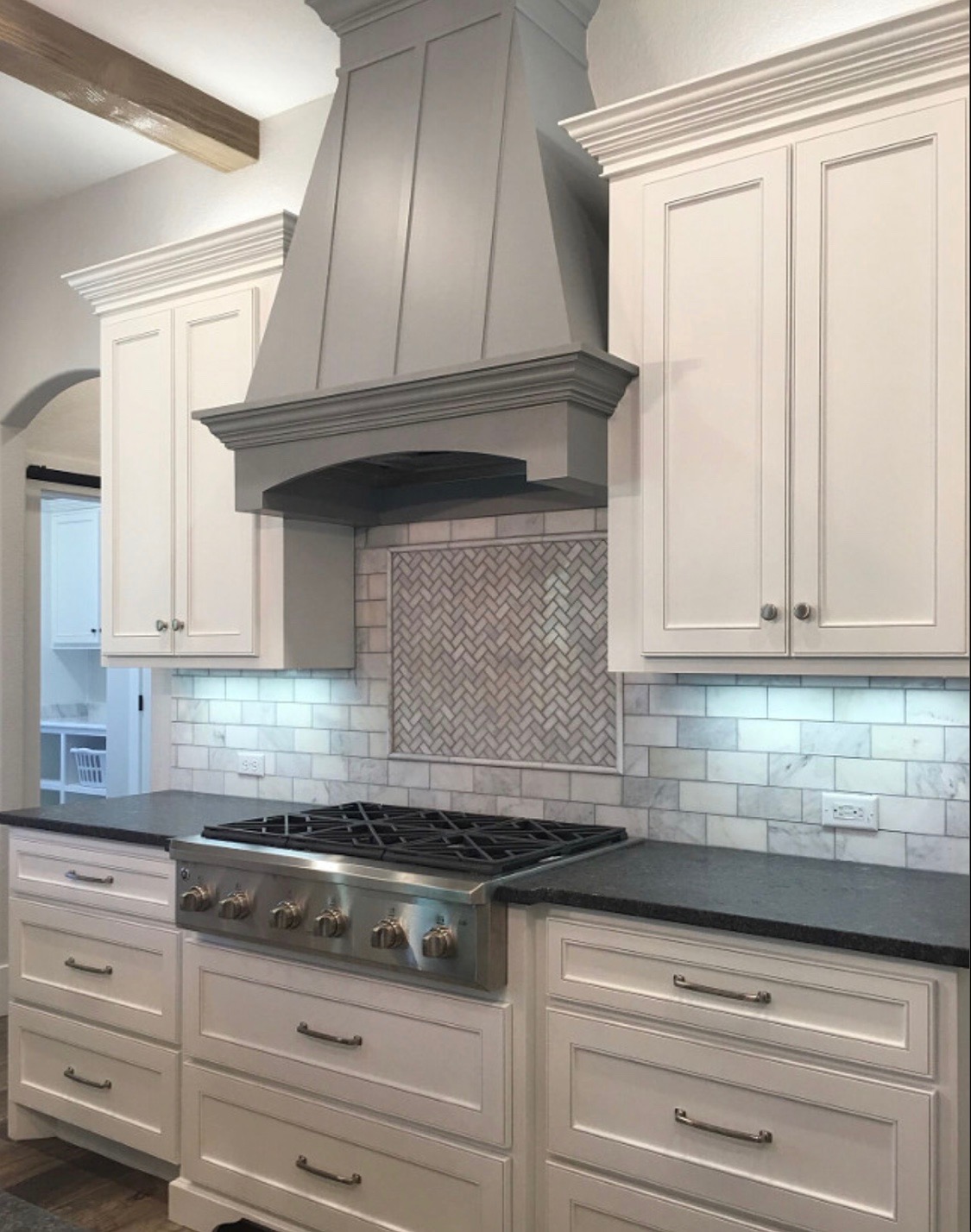 Detailed gray custom range hood with white cabinetry