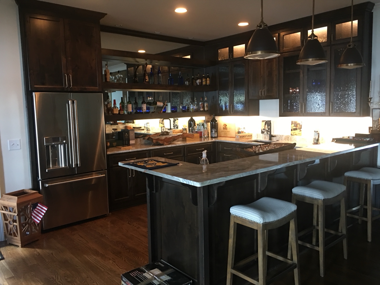 Dark wood custom bar cabinetry with glass doors