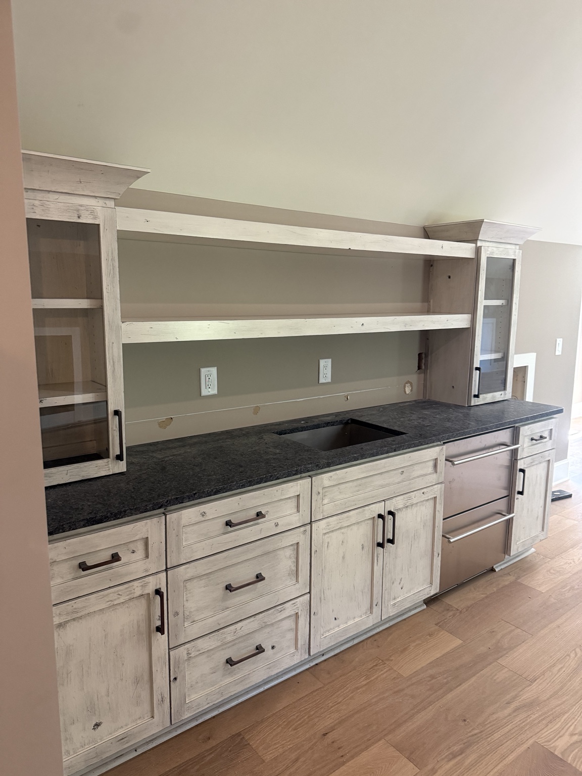 Distressed finish cabinetry with black countertop
