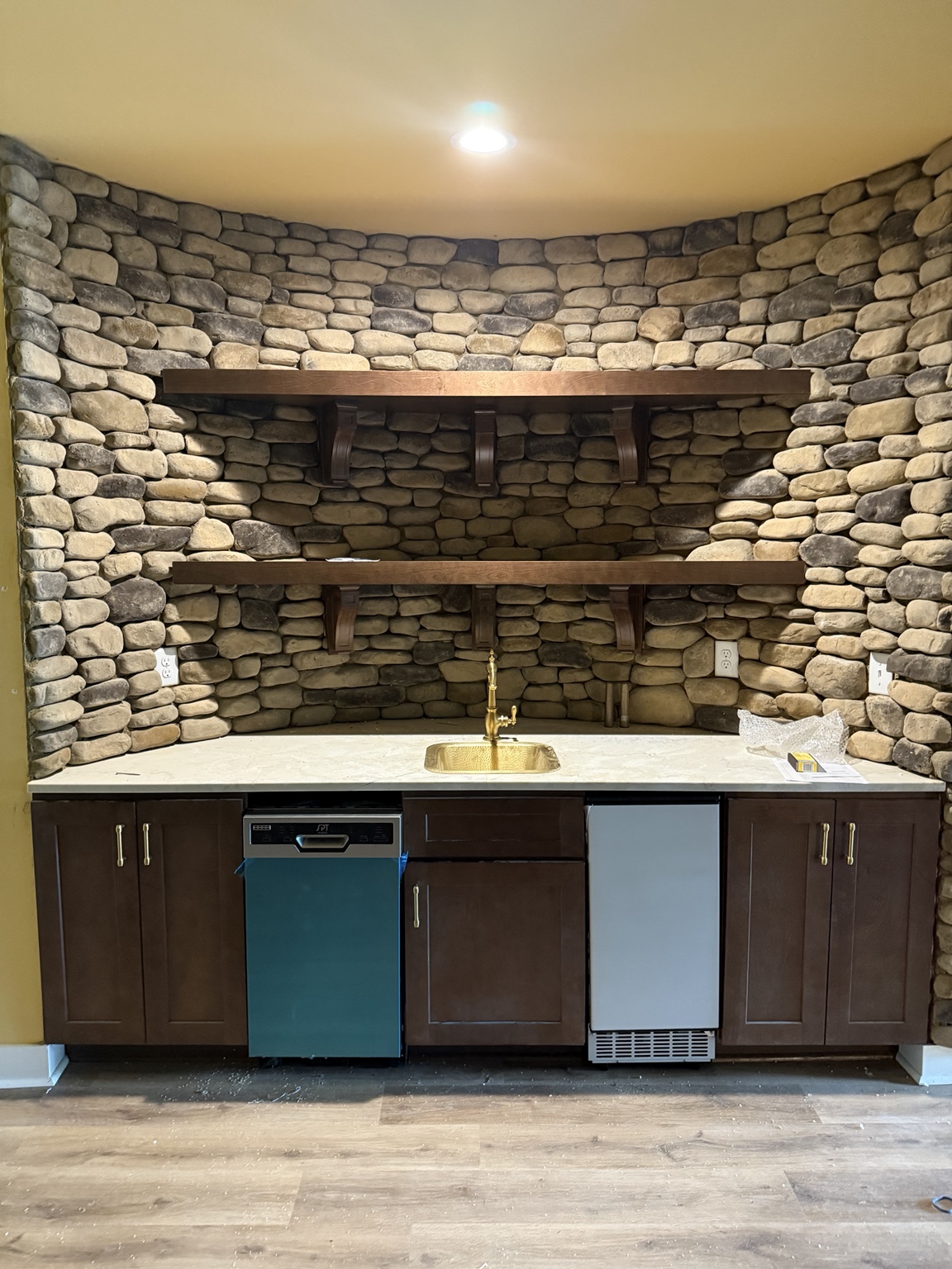 Custom bar cabinetry set against a natural stone wall